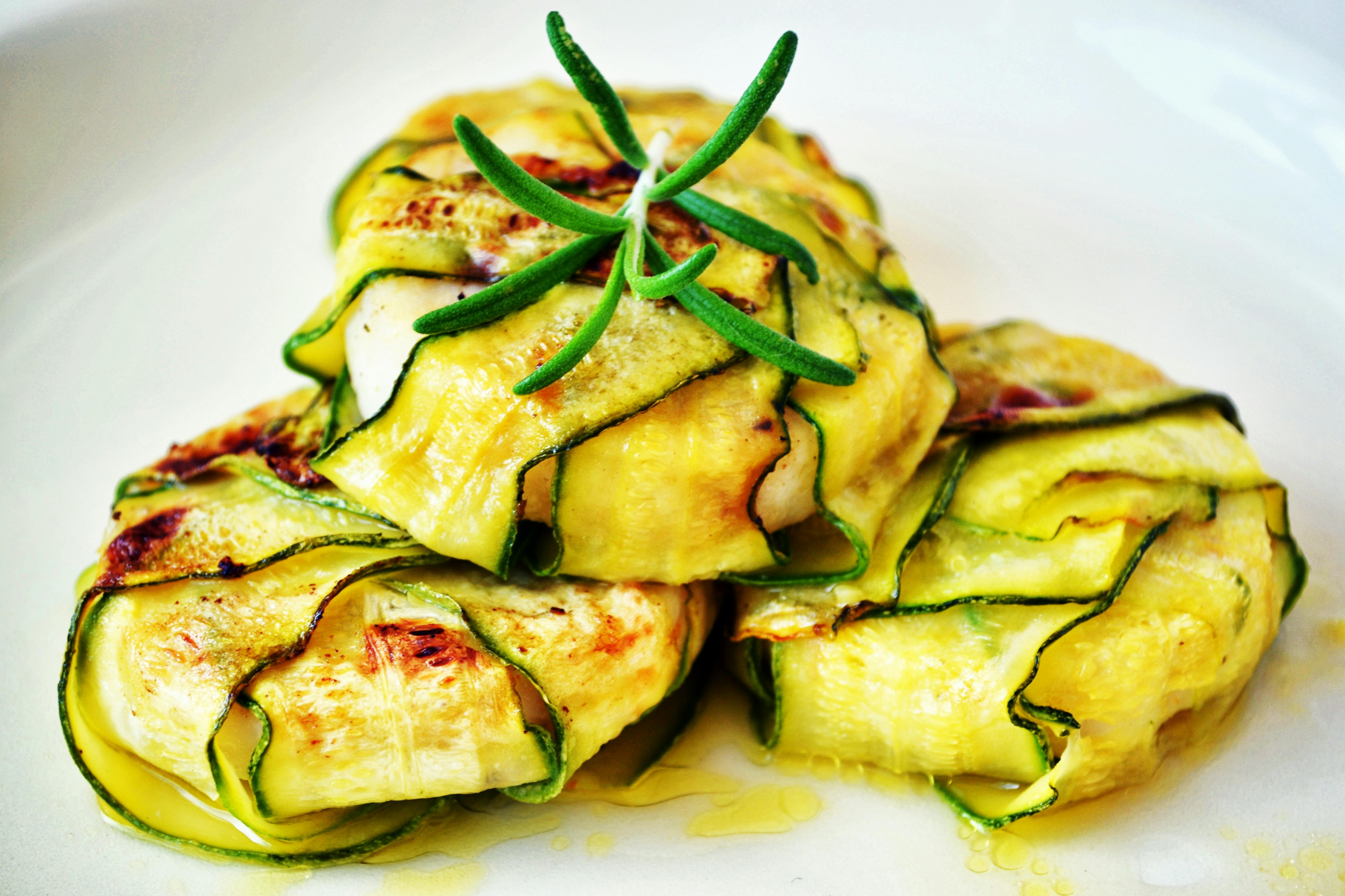 Plato con calabacines a la parrilla envueltos alrededor de pequeños quesos tomini.