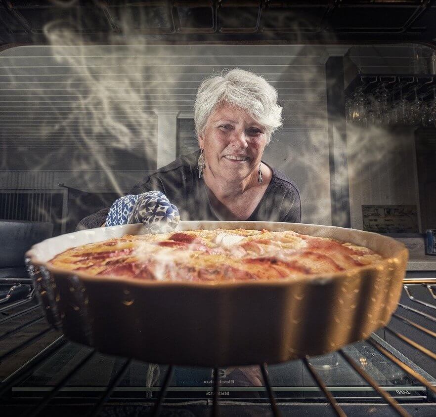 mujer que cocina en el horno